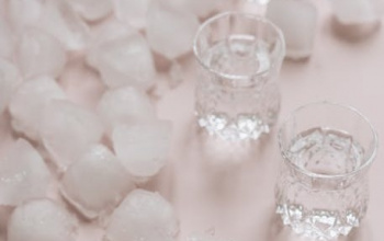 Shots of vodka with ice on table